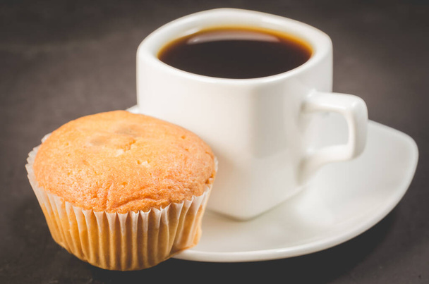 coffee break. White cup of the hot black coffee and muffin. Breakfast concep - Фото, зображення