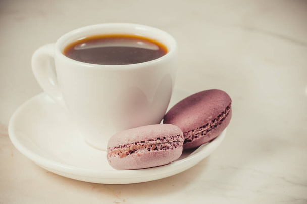 sweet macaroons or macaron and coffee cup on a white background, close up. French dessert - Photo, Image