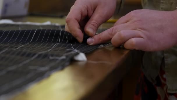 Fashion designer hands basting the front of a suit. In sewing, to tack or baste is to make quick, temporary stitching intended to be removed. Tacking is used in a variety of ways - Footage, Video