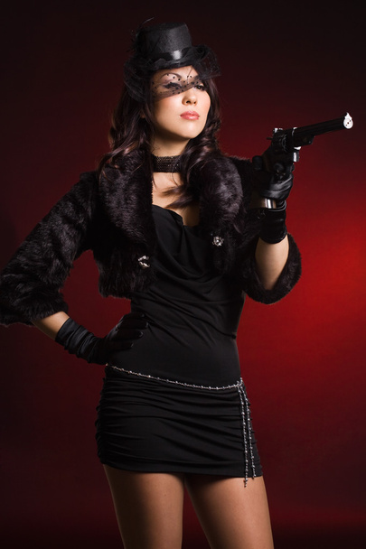 Elegant lady with a pistol in hands - Foto, afbeelding
