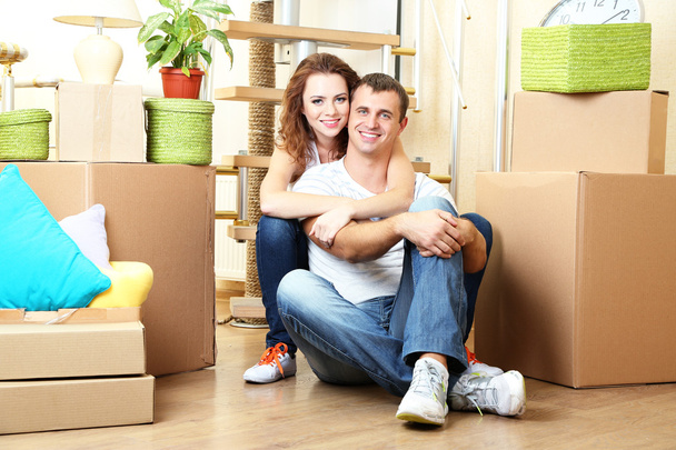 Young couple sitting in new house on staircase background - Photo, image