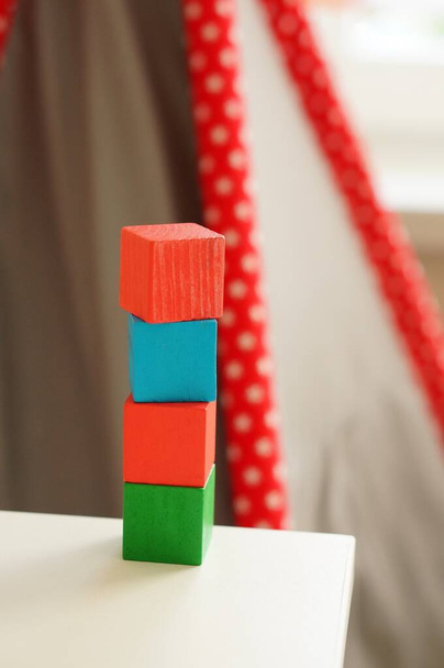 A stack of colorful wooden toy blocks on a white surface - Fotó, kép