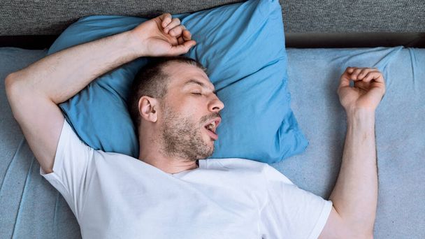 Mies nukkuu sängyssä kotona pandemian aikana Self-eristys, Panorama
 - Valokuva, kuva