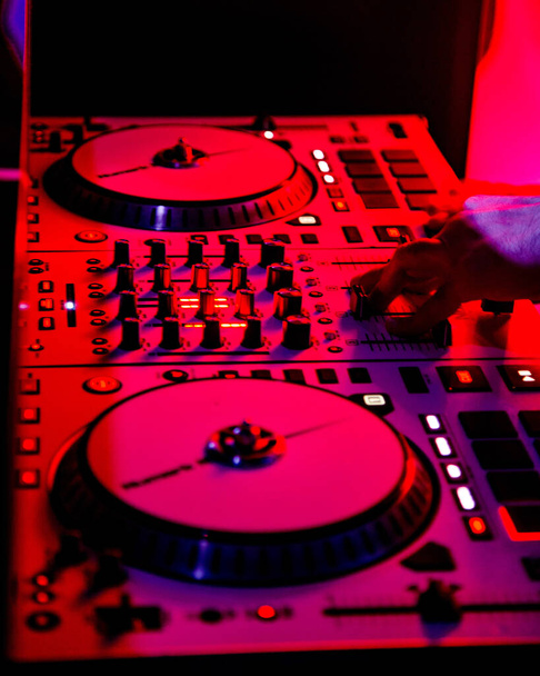 диджей, играющий в dj setup в клубе в розовых огнях
 - Фото, изображение