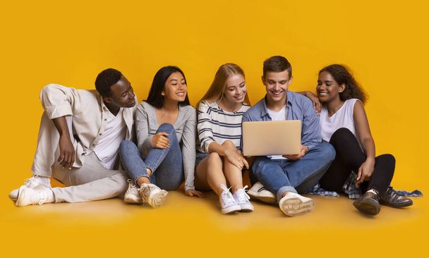 Internationale Gruppe von Teenagern nutzt gemeinsam Laptop - Foto, Bild