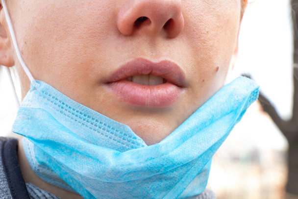closeup of a young Ukrainian woman in a medical mask on her face during - Photo, Image