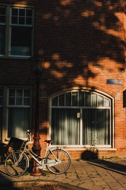 Bicicletta vintage su strada con muro di mattoni sfondo soleggiato
 - Foto, immagini