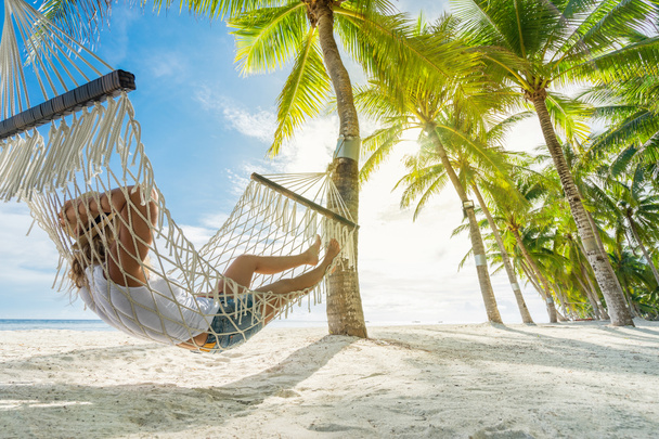 Γυναίκα χαλαρώνει στην αιώρα στην παραλία. Σχέδιο ταξιδιού και διακοπών. Έκδοση banner. - Φωτογραφία, εικόνα
