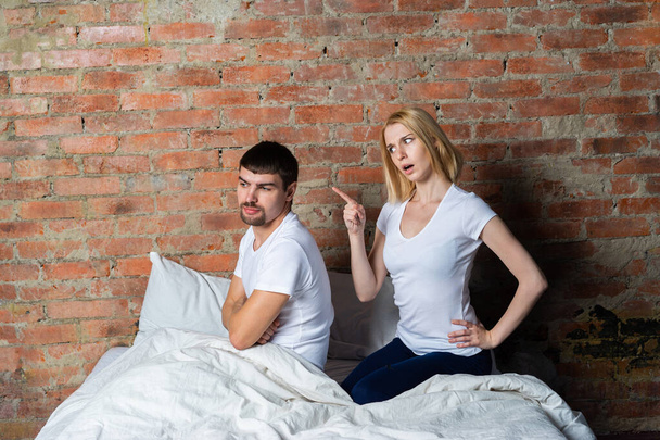 Two upset young partners having domestic quarrel in bedroom. - Фото, изображение