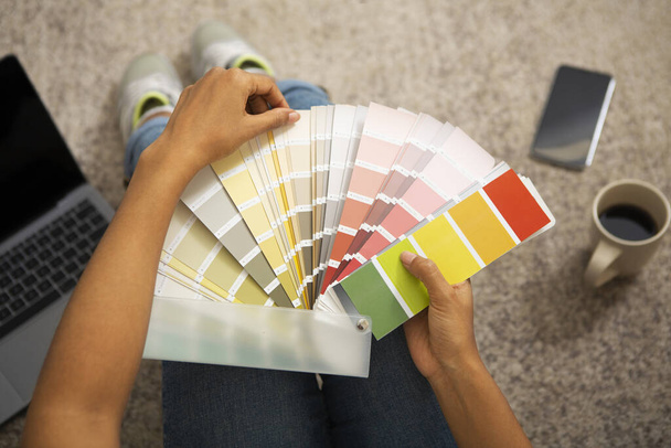 Девушка выбирает краску для интерьера из цветных образцов
 - Фото, изображение