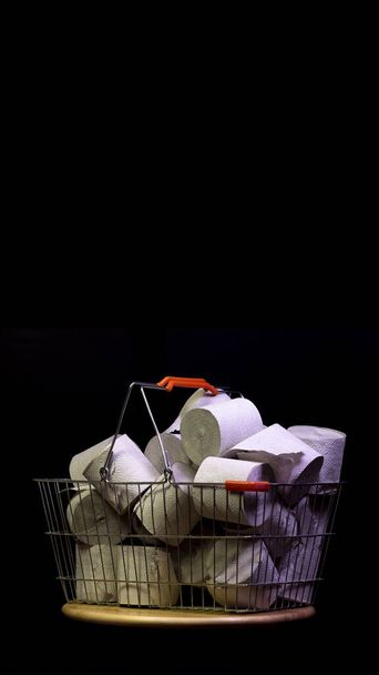 Shopping basket with rolls of toilet paper isolated on black background.Copy space.Vertical social media frame.Ready for stories. - Photo, Image