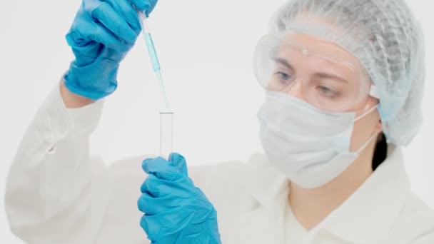 Lovely caucasian female scientist in laboratory puts a blue faci - Video