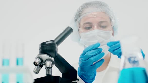 Young female reproductive clinic employee examines biological sa - Felvétel, videó