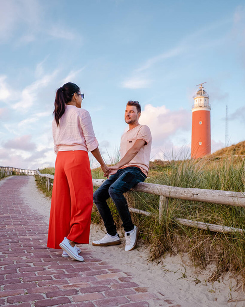 Тесельний маяк під час заходу сонця Голландський острів Тексел, подружжя відвідує маяк, чоловіків і жінок у відпустці Тексел. - Фото, зображення