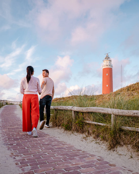 Vuurtoren Texel bij zonsondergang Nederlands eiland Texel, koppel bezoek de vuurtoren, mannen en vrouw op vakantie Texel - Foto, afbeelding