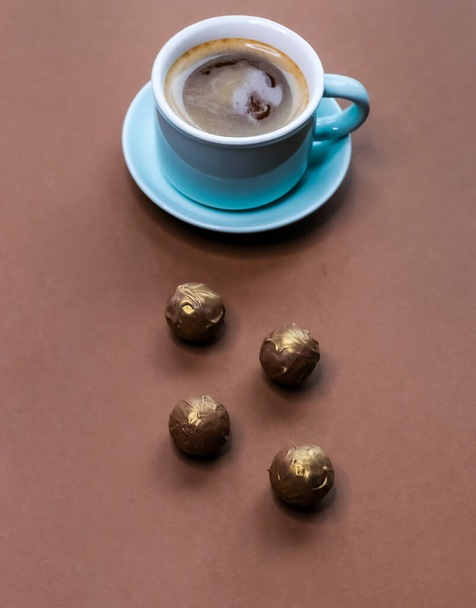 ミントグリーンカップのコーヒーエスプレッソとダークチョコレートトリュフの茶色の背景.  - 写真・画像