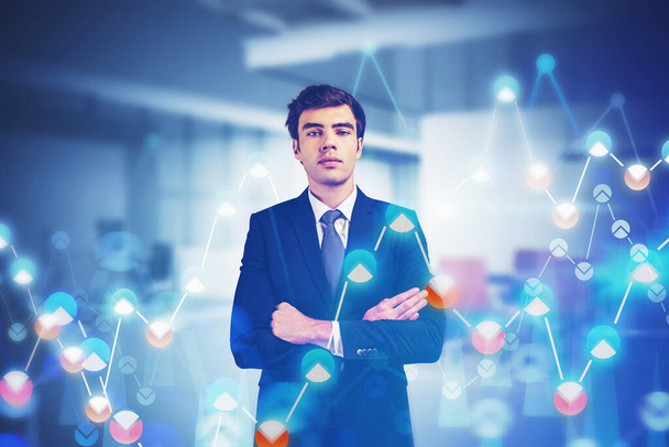 Portrait of confident young European businessman standing in blurry office with double exposure of financial graphs. Concept of stock market and investment. Toned image - Photo, Image