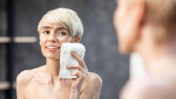 Dame séchage visage à l'aide de serviette dans la salle de bain à la maison, Panorama
 - Photo, image