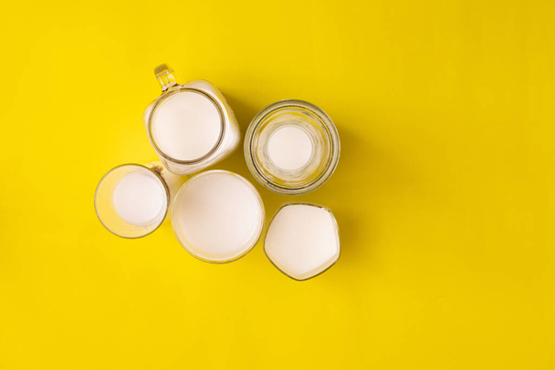 Grupo vaso de leche sobre fondo amarillo con espacio de copia, vista desde la mesa de arriba
. - Foto, imagen