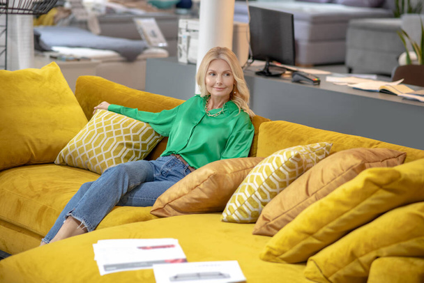 Blonde woman in a green blouse looking relaxed - Fotoğraf, Görsel