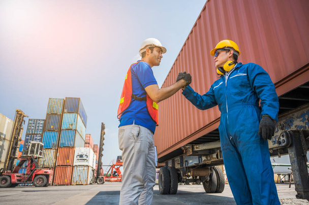 Foreman and dock worker staff shaking hand for sucess working at Container cargo harbor. Business Logistics import export shipping concept. - 写真・画像