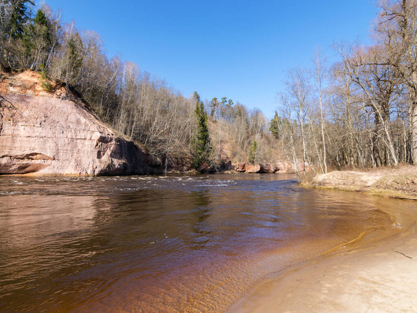 encantador paisaje de primavera con acantilados de piedra arenisca en la orilla del río, caudal rápido y agua clara del río, acantilados Kuku, río Gauja, Letonia
 - Foto, imagen