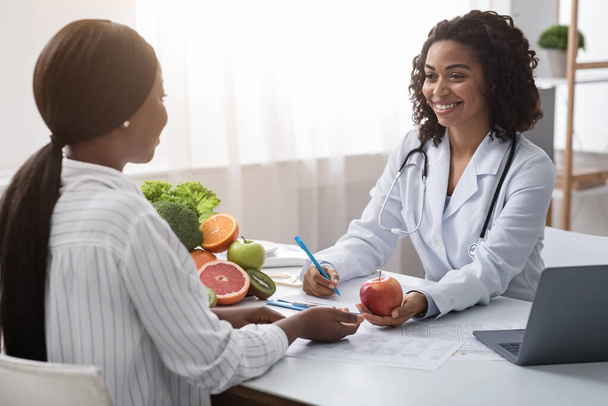 Nutricionista feliz dando consulta al paciente sobre alimentación saludable
 - Foto, Imagen