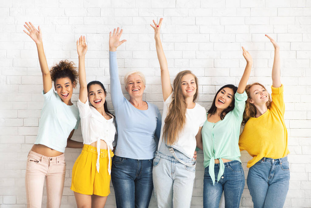 Multiethnic Ladies Waving Hands Posing Against White Brick Wall Backgound - Photo, image