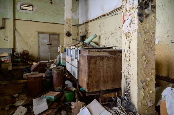 Photo of a garbage dump in an abandoned room of a destroyed factory - Фото, изображение