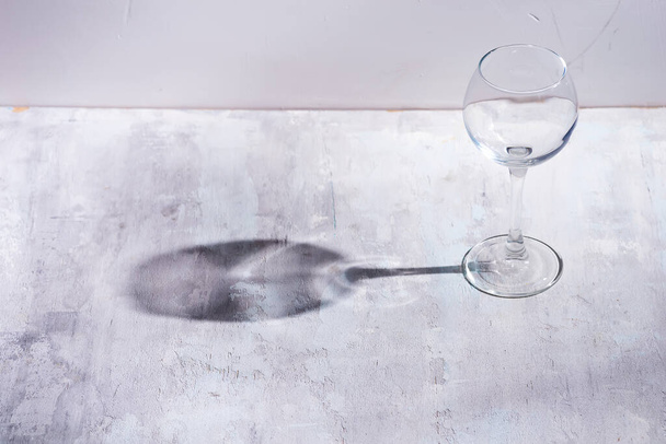 Γυαλί κρασιού με ήλιο σκληρό φως αντανάκλαση σκιά σε πέτρα φόντο - Φωτογραφία, εικόνα