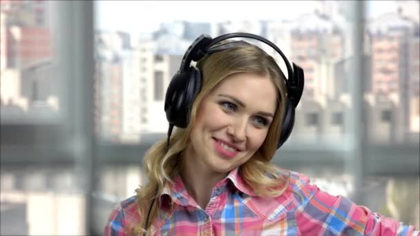 Retrato de una joven mujer feliz usando auriculares y hablando
. - Metraje, vídeo
