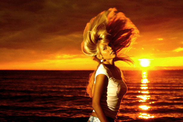 Schöne Mädchenhaare winken auf goldenem Sonnenuntergang über dem Meer - Foto, Bild