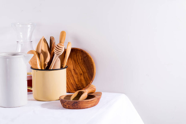 Geschirr aus Holz in Eisentasse mit Holzteller auf weißem Textiltisch. Kochgeräte. Keine Verschwendung - Foto, Bild