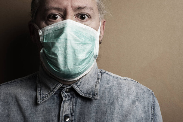 Ιός Κορόνα. Ο φοβισμένος άνθρωπος από τον ιό της μετάδοσης φοράει προστατευτική μάσκα - Φωτογραφία, εικόνα