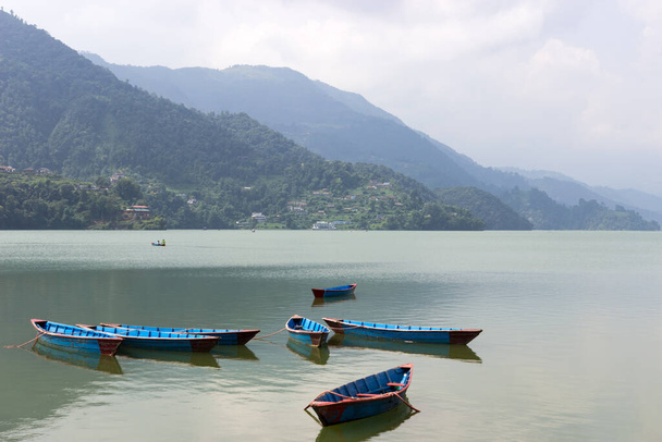 small boats of different colors of paint, on the surface of a clear lake.No tourists in a tourist vacation destination.Borders closed due to coronavirus and fewer tourists harming business - Photo, Image