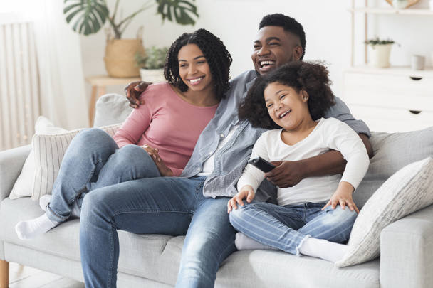 Happy black family relaxing and at home, watching tv together - Foto, immagini