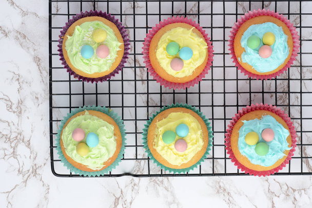 easter cupcakes with eggs cooling on wire rack - 写真・画像