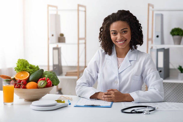 Houkutteleva naisten ravitsemusterapeutin poseeraa hänen moderni toimisto
 - Valokuva, kuva