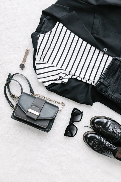 накладний плоский вигляд жінка одяг чорно-біла сумка джинси взуття блейзер сонцезахисні окуляри
 - Фото, зображення