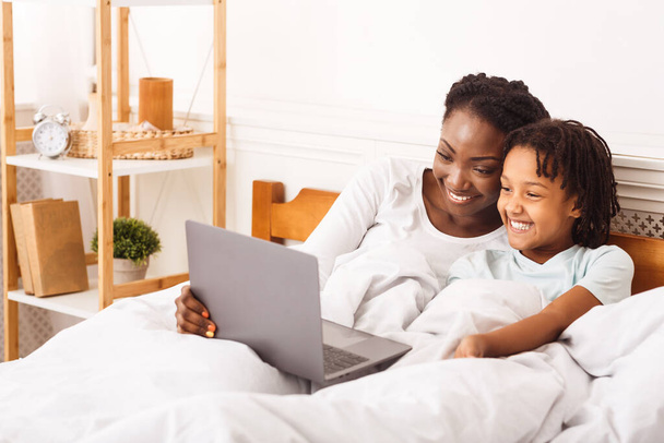 Afrikai amerikai nő és lány néz rajzfilmeket laptopon - Fotó, kép