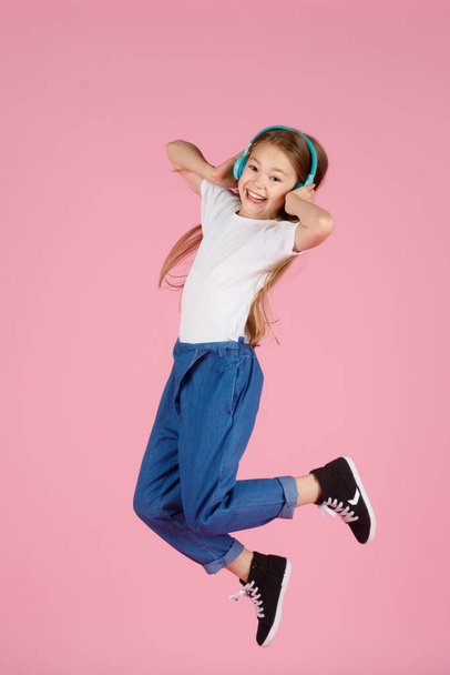 Dancing and singing. Teenager listen music. Recommended music based initial interest. Free music apps for mobile device. Energetic playlist. Girl cute schoolgirl white clothes headphones listen music. - Fotó, kép