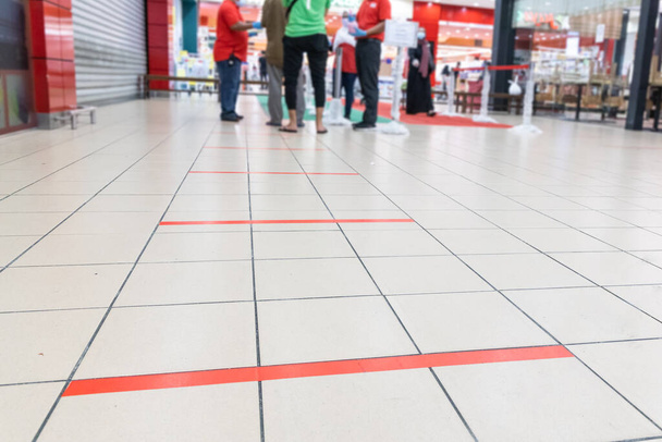 Distanza sociale praticata all'ingresso del supermercato in Malesia con 1 metro di distanza tra le persone in coda
. - Foto, immagini