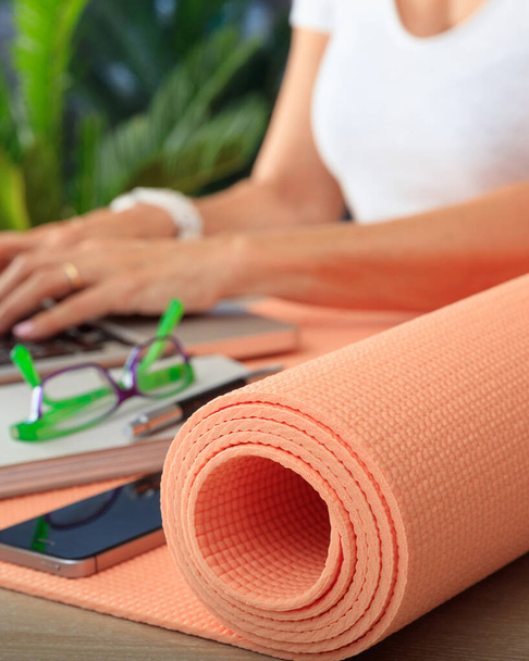 Business and healthy lifestyle concept. Yoga mat on an office desk closeup view, fit woman at workplace - Photo, Image