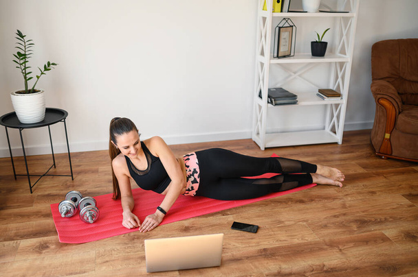 Mulher fazendo fitness em casa com vídeo tutorial
 - Foto, Imagem