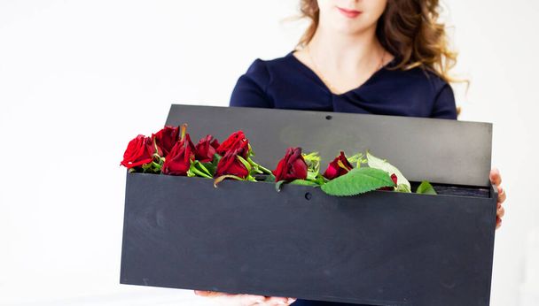 man gives red roses in an original box to his beloved woman - Foto, imagen
