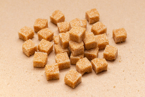 коричневые кубики сахара на бумажном фоне
 - Фото, изображение