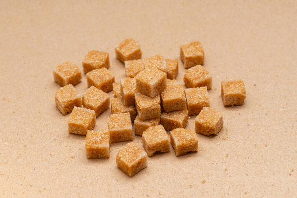 коричневые кубики сахара на бумажном фоне
 - Фото, изображение
