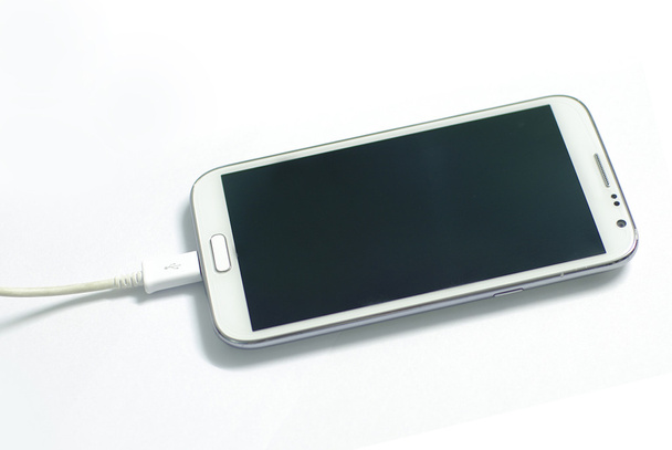 charging white mobile device - Foto, Bild