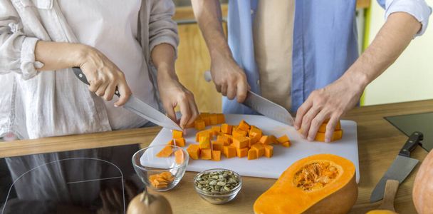 Young unrecognizable couple preparing healthy lunch of fresh baked pumpkin - Photo, Image