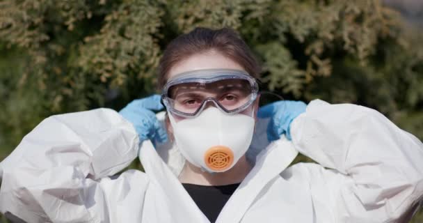 Portrait of epidemiologist protecting patients from coronavirus COVID-19 in mask. Global pandemic epidemic Europe, Italy, USA. Doctor virologist Takes on virologist suit - Filmagem, Vídeo